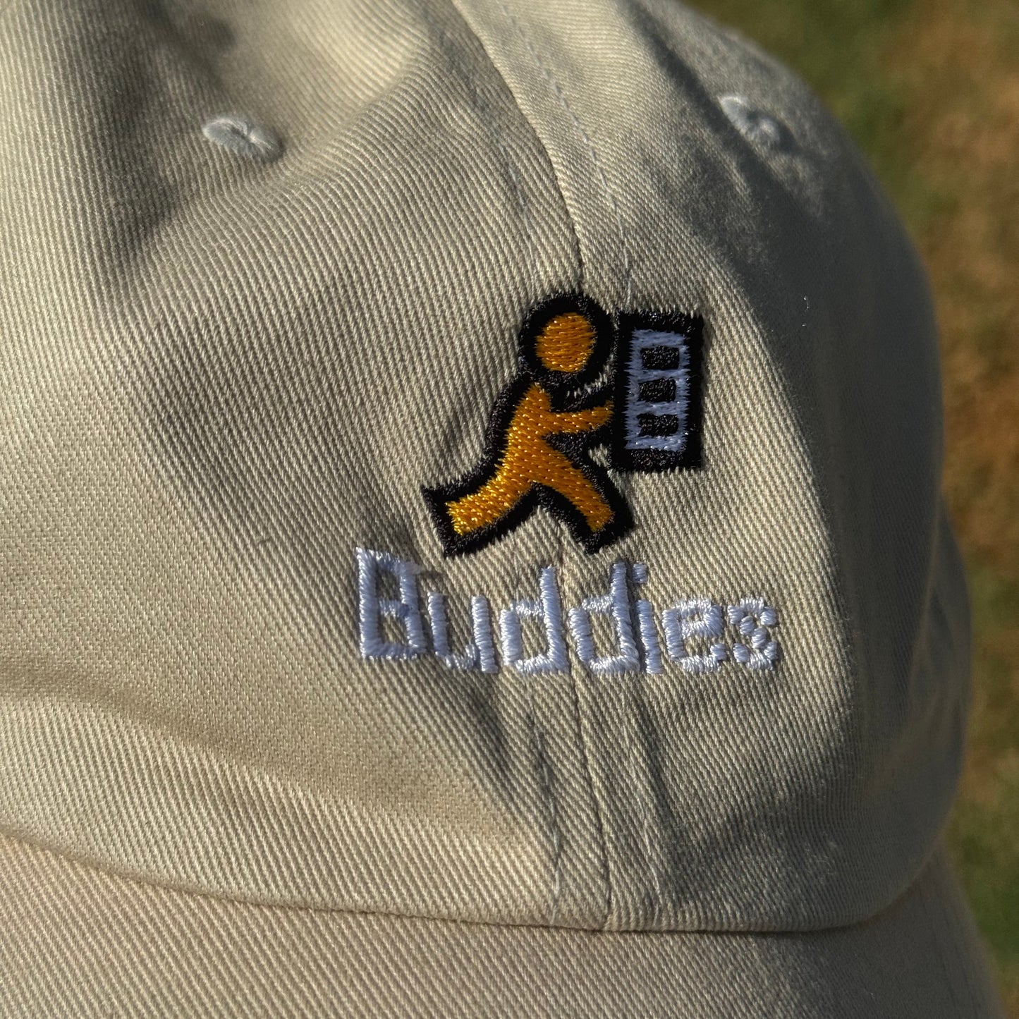 Close-up of a cap with a AOL's AIM Buddy List icon and text on a blurred background